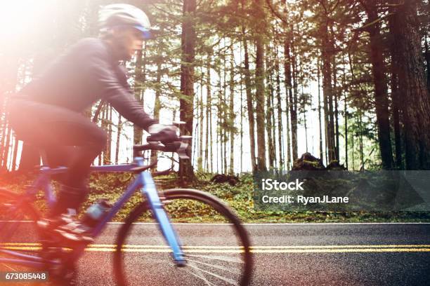 Cyclist Riding Mountain Road On Racing Bike Stock Photo - Download Image Now - Road Cycling, Active Lifestyle, Adult