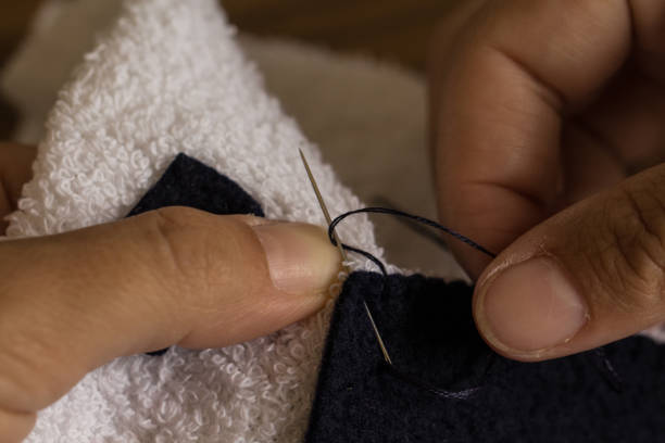 istock Woman hands sewing towel with needle and thread 673109060