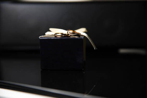 istock Bride and groom rings in wedding box on black background 673114578