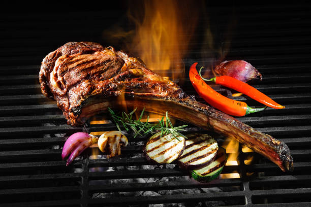 Tomahawk rib beef steak on grill Tomahawk rib beef steak on hot black grill with flames Ribeye Steak stock pictures, royalty-free photos & images