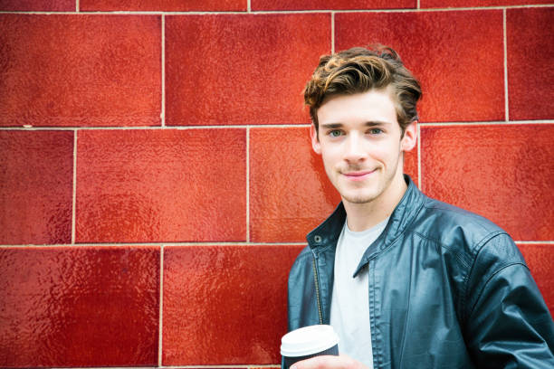 istock Millennial British man portrait against red wall with coffee 673114830