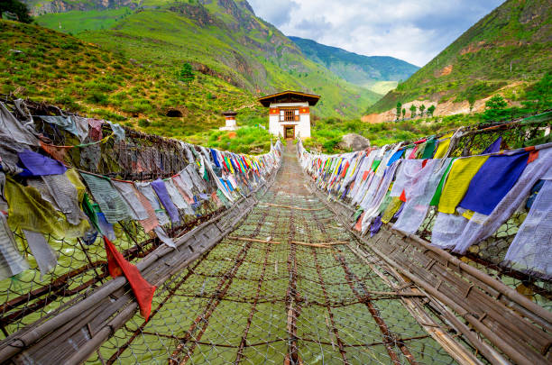 walking with faith walking suspension bridge with a lot of colorful prayer flags in Bhutan bhutan stock pictures, royalty-free photos & images