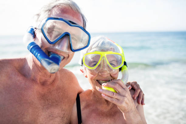 istock Happy senior couple with their diving mask at beach 673127720
