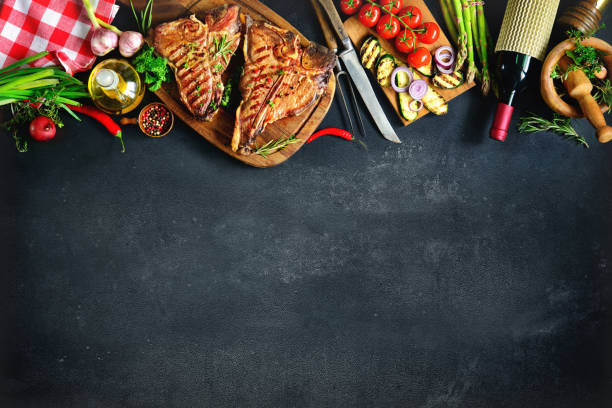 istock Grilled T-bone steaks with fresh herbs and vegetables 673139344
