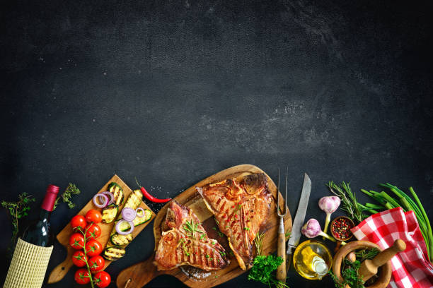 istock Grilled T-bone steaks with fresh herbs and vegetables 673139354