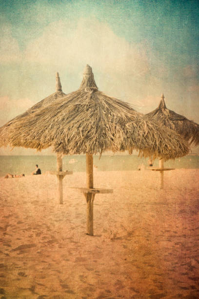Vintage texture style view of tropical beach with grass hut palapas