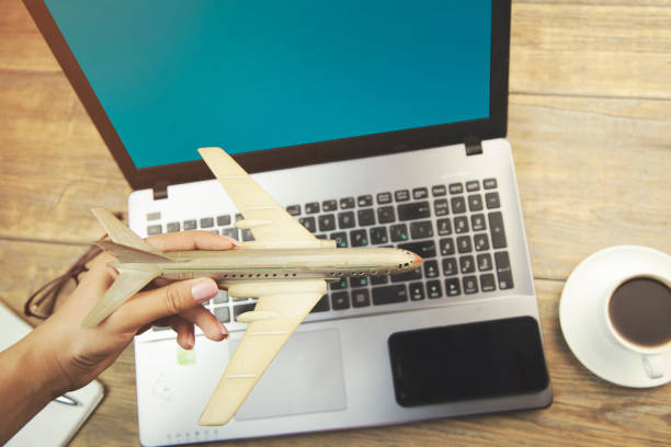 istock Woman hand airplane and phone on computer keyboard 673149040