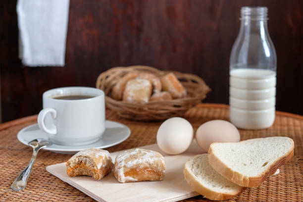 istock Breakfast with cup of coffee gingerbread eggs bread and milk in bottle on table soft lighted on dark background textured with scratches/more bright background 673149076