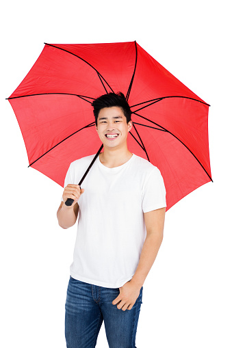 Happy young man holding a umbrella on white background