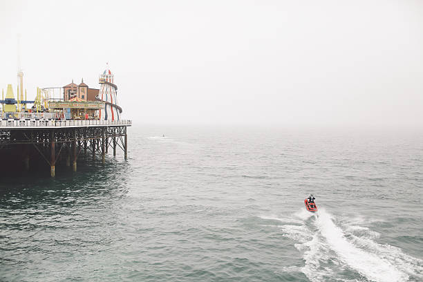 rear view of man jet boating on sea by brighton pier - wake jet boat water water sport imagens e fotografias de stock