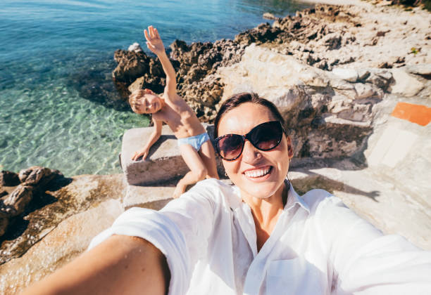 мать с сыном сделать отпуск селфи фото в адриатическом море залива - fun mother sunglasses family стоковые фото и изображения