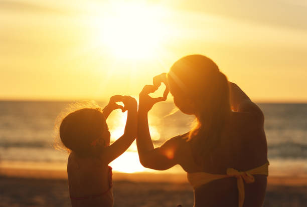 愛、家族、幸せな家族の概念。夕暮れ時の手から母と子の娘を心 - heart shape child human hand childhood ストックフォトと画像