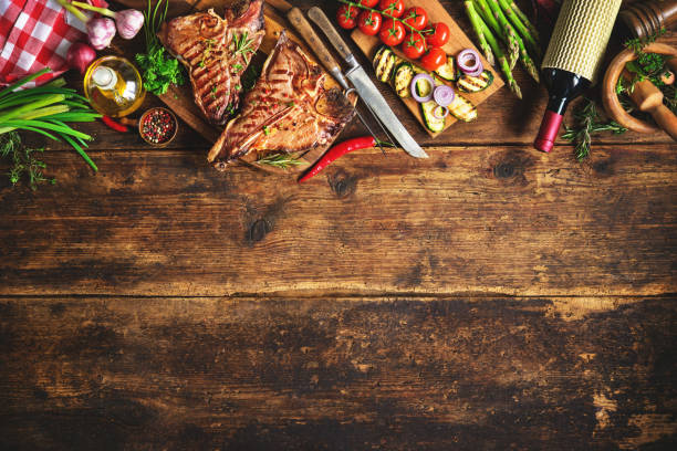istock Grilled T-bone steaks with fresh herbs, vegetables ans wine bottle 673162958
