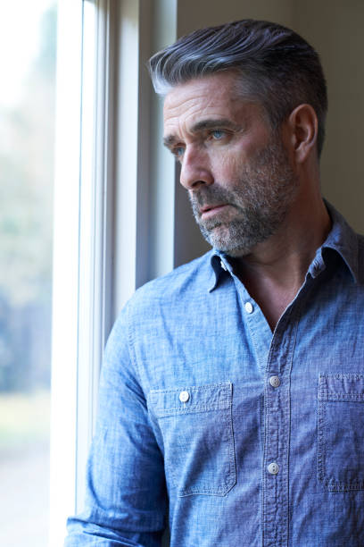 istock Mature Man Suffering From Depression Looking Out Of Window 673165606