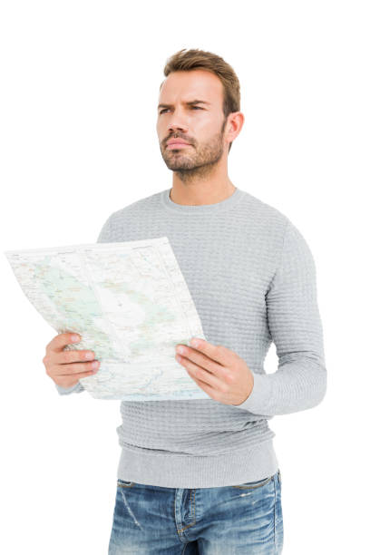 hombre serio joven sosteniendo un mapa - explorer tourist frowning men fotografías e imágenes de stock