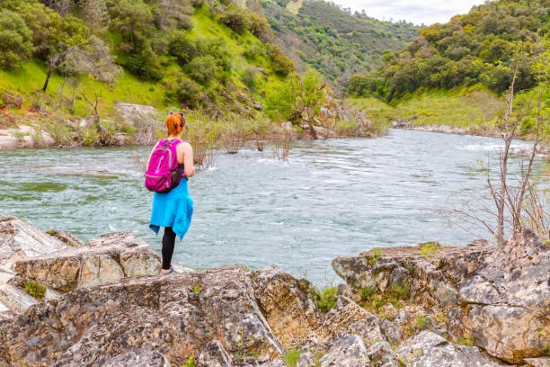 istock Girl Standing on Rocks Near Fast River 673189602