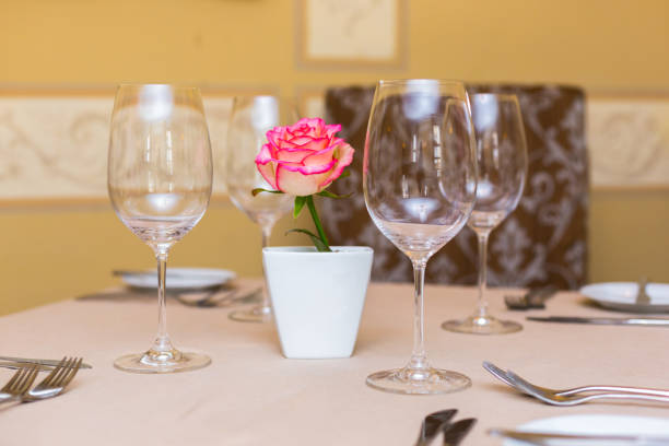 istock Pink rose in a vase as table decoration. Table setting 673192794