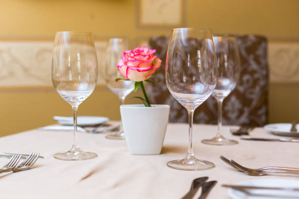 istock Pink rose in a vase as table decoration. Table setting 673192828