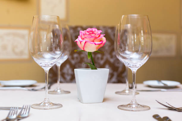 istock Pink rose in a vase as table decoration. Table setting 673192938
