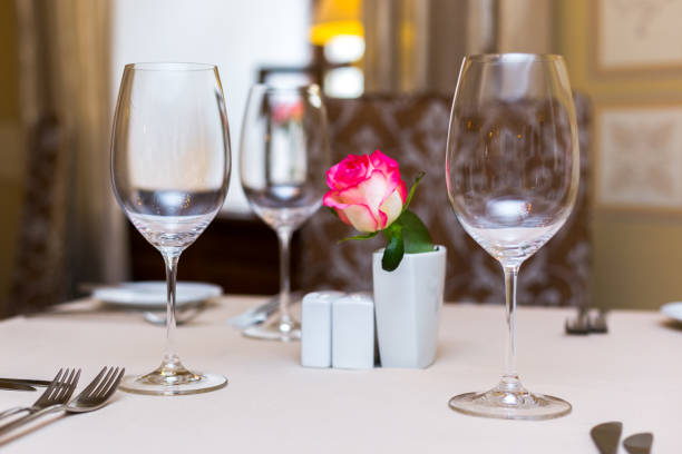 istock Pink rose in a vase as table decoration. Table setting 673193066