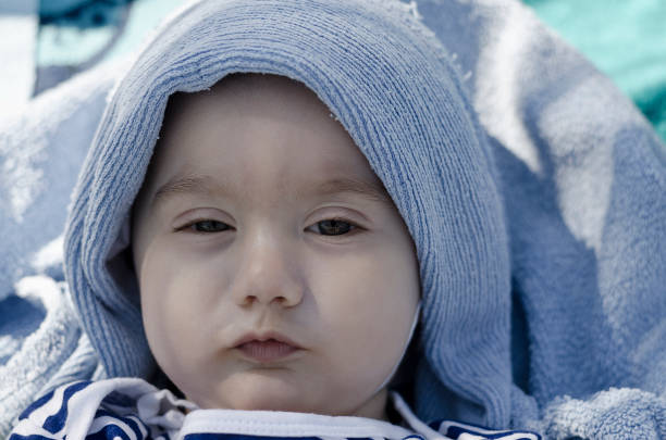 Cute baby face wrapped in towel with sparkling eyes