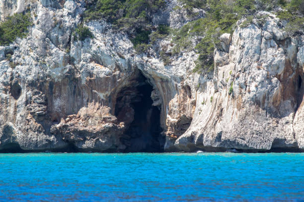 Blue sea and the characteristic caves of Cala Luna, a beach in the Golfo di Orosei, Sardinia, Italy