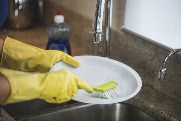 Woman washing up in the kitchen at home