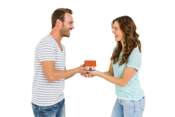 istock Happy young couple holding model house 673197612