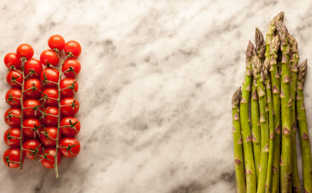 asparagus and cherry tomatoes on marble background