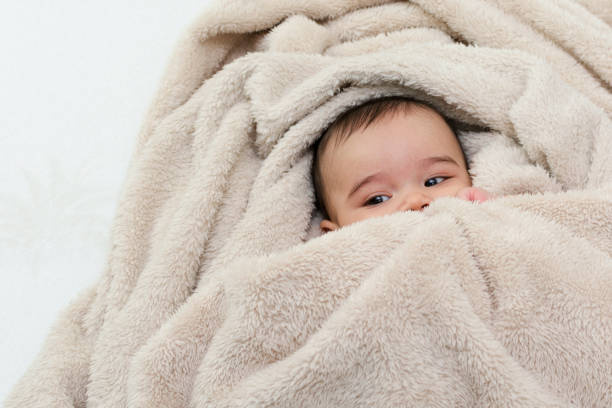 istock Cute baby boy in bed under a fluffy blanket 673203506