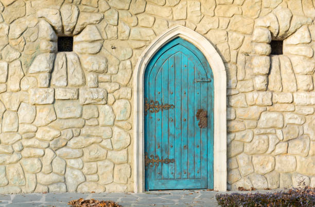 antigua puerta de madera azul de una construcción medieval - gothic style castle church arch fotografías e imágenes de stock
