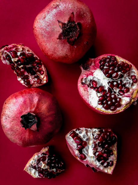 istock Ripe fresh pomegranate fruit on red colored background top view 673206196