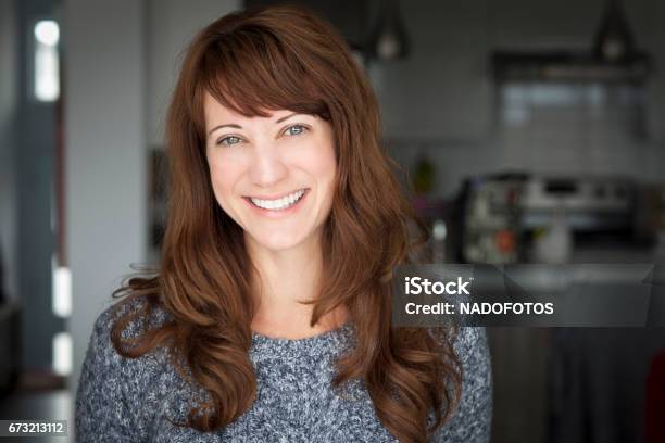 Portrait Of A Mature Woman Smiling At The Camera In The Kitchen Stock Photo - Download Image Now