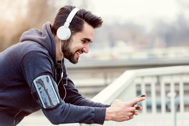 istock Man jogger with smartphone and headphones in sunset 673213122