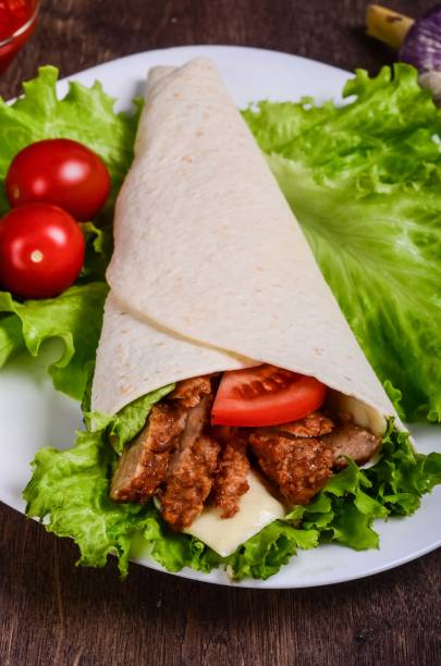 istock Burito with meat. Fried pork, beef, tomatoes 673223822