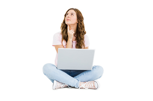 Thoughtful young woman using laptop on white background