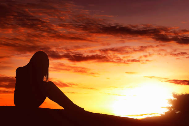 istock Silhouette sad expression woman sitting alone on top of the hill 673233048