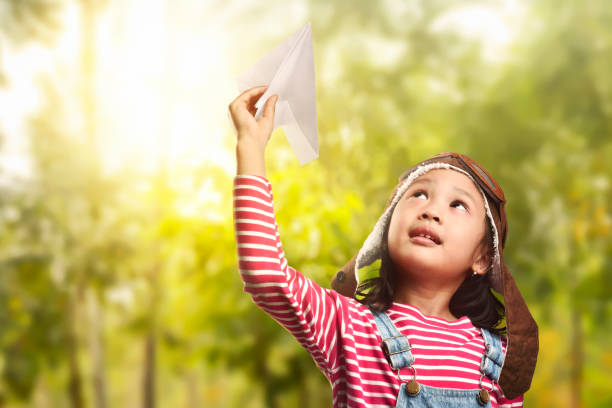istock Cheerful asian child playing with paper plane 673233700