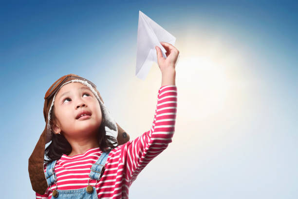 istock Happy asian kid with toy paper plane having fun 673233718