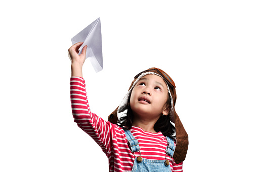 Happy asian little girl playing with toy paper airplane isolated over white background