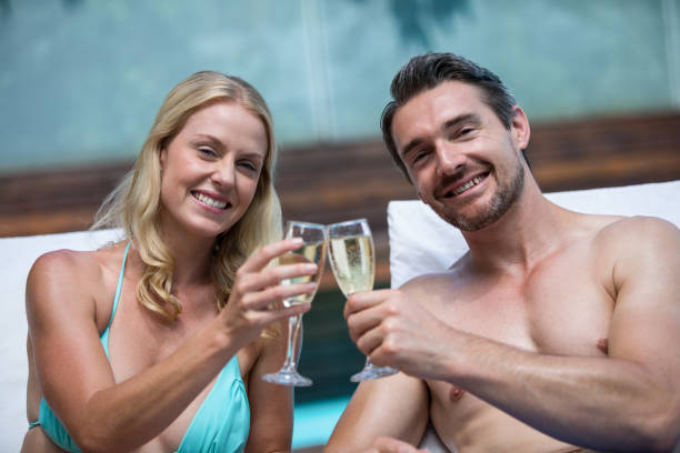 pareja sentada en la tumbona tostado champagne - sports venue luxury love enjoyment fotografías e imágenes de stock