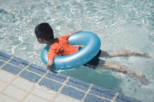 istock Cute boy swimming in pool 673247036