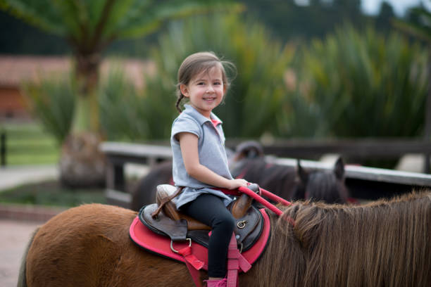 istock Girl smiles riding on her pony 673247324