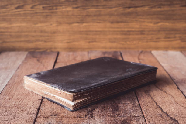 istock Old hardback book on wooden table. 673263328