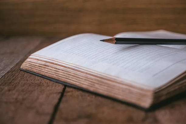 istock Blank notebook with pencil on wooden table. Selective focus 673263436