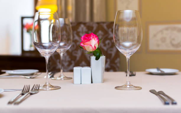 istock Pink rose in a vase as table decoration. Table setting 673292192