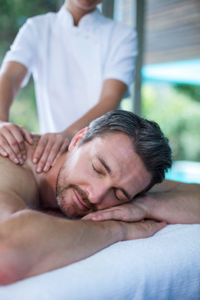man receiving back massage from masseur - massage table massaging sport spa treatment imagens e fotografias de stock