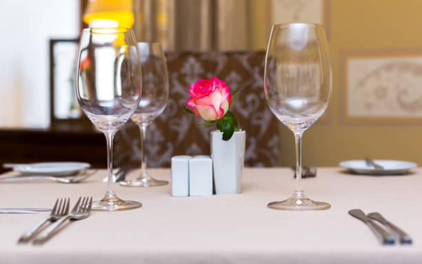 istock Pink rose in a vase as table decoration. Table setting 673304646