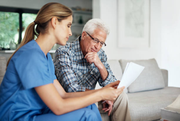 I'll go over the paperwork with you... Shot of a female nurse discussing paperwork with her senior patient registration form photos stock pictures, royalty-free photos & images