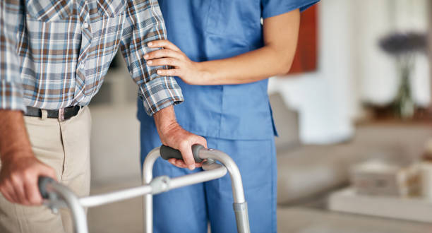 Sometimes a family needs that extra special touch Shot of a woman assisting her elderly patient who's using a walker for support nursing home stock pictures, royalty-free photos & images